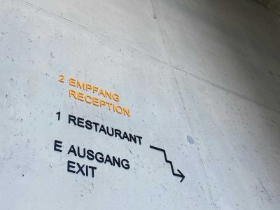 3-d-schrift-schwarz-gelb-corporate-identity-flur-treppenhaus-leitsystem-betonwand